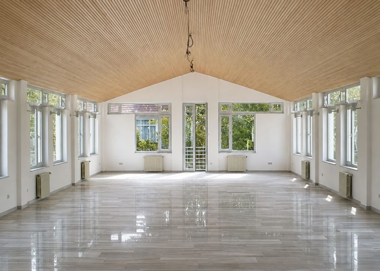 Red Cross / Kızılay Branch Office empty hall with slatted timber ceiling, tall windows, and reflective floor
