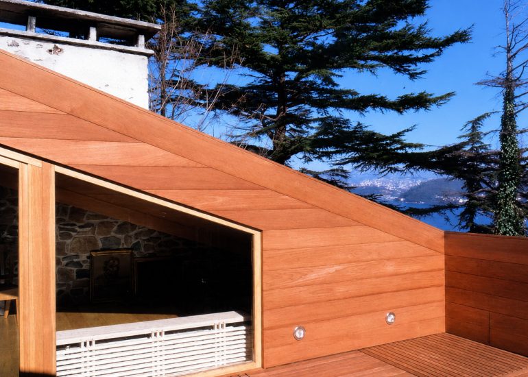 Residence Emirgan exterior with sloped wood-clad wall, framed opening, and distant water view